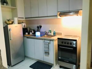 a kitchen with a stainless steel refrigerator and a sink at One Bedroom with Netflix at Legaspi Village Makati in Manila