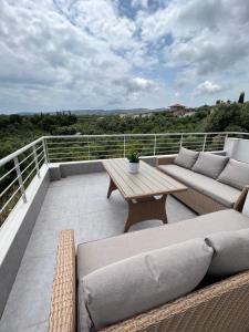 a patio with couches and a table on a balcony at Koroni Luxury Maisonette in Koroni