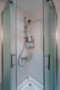 a shower with a glass door next to a sink at 2-room Apartment Gudauri Penta 303 in Gudauri