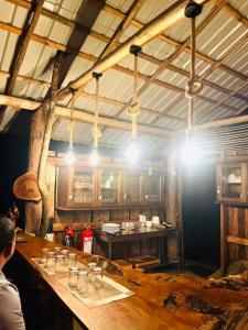 a kitchen with a bar with glasses on it at Watersmeet Glamping in Deraniyagala