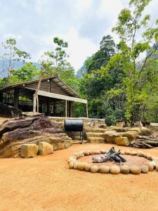 a building with a circle of rocks in the dirt at Watersmeet Glamping in Deraniyagala