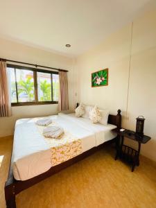 a bedroom with a large bed and a table at Meewaya Hotel in Chaweng