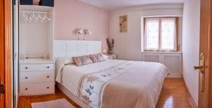 a white bedroom with a bed and a window at El Mirador in Paralacuesta