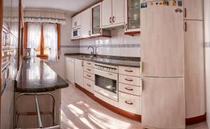 eine Küche mit einem Kühlschrank, einer Spüle und einer Theke in der Unterkunft El Mirador in Paralacuesta