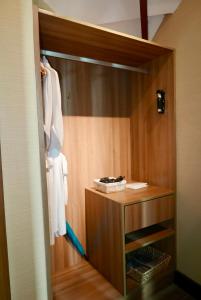 a bathroom with a closet with a wooden door at Acuatico Beach Resort & Hotel Inc. in San Juan