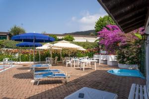 patio ze stołami, krzesłami i parasolami w obiekcie 070 - Villa OLANDA con veranda VISTA MARE a 5 minuti SPIAGGIA con PISCINA CONDOMINIALE w mieście Sestri Levante