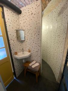 a small bathroom with a sink and a bench at Le Colombier de Malpas in Quingey