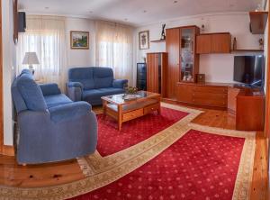 een woonkamer met twee blauwe stoelen en een televisie bij El Mirador 2 in Paralacuesta