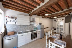 une cuisine avec des placards blancs et une table en bois dans l'établissement Podere del Ciacchi Among Tuscany Greenery - Happy Rentals, à Montieri