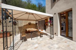 un patio con mesa y sombrilla en Podere del Ciacchi Among Tuscany Greenery - Happy Rentals, en Montieri