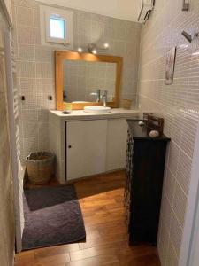 ein Bad mit einem Waschbecken und einem Spiegel in der Unterkunft La Jas, demeure climatisée au charme gardois. in Nages-et-Solorgues