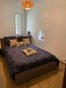 um quarto com uma cama grande e um cobertor azul em La Jas, demeure climatisée au charme gardois. em Nages-et-Solorgues