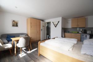 ein Schlafzimmer mit Bett und Tisch und eine Küche in der Unterkunft Bernsteinbäder Zimmer in Ostseebad Koserow