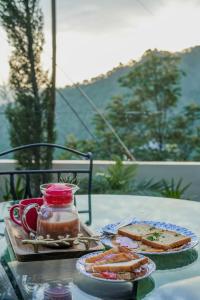 einen Tisch mit einem Teller Brot und einem Glas Soße in der Unterkunft SaffronStays Summer Estate in Kasauli