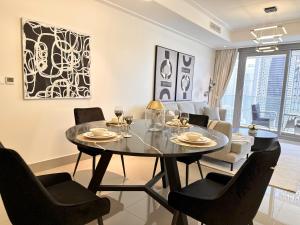 comedor y sala de estar con mesa y sillas en Luxurious 3 Bedroom Apartment with Burj Khalifa & Fountain View by Luxstay Holiday Homes, en Dubái