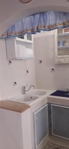 a white bathroom with a sink and a counter at Casina del castello in Castelnuovo della Misericordia