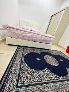 a rug sitting on the floor next to a bed at Homestay Denai Universiti near UMK 3 rooms aircond with wifi in Bachok