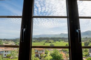 een raam met uitzicht op een groen veld bij Casa en Llanes cerca de la playa, Niembru. El Carrascal in Llanes