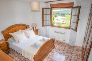 Un dormitorio con una cama grande y una ventana en Casa en Llanes cerca de la playa, Niembru. El Carrascal, en Llanes