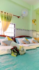 Thai Quang Hotel في فنغ تاو: غرفة نوم بسريرين مع ورود وحيوانات محشوة