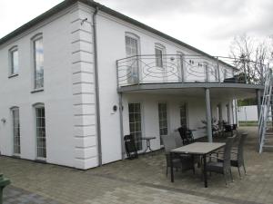 a white house with a table and a balcony at White House Hotel Apartments in Brande
