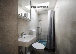 ein Badezimmer mit Waschbecken, Toilette und Dusche in der Unterkunft Bernsteinbäder Zimmer in Ostseebad Koserow
