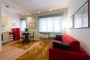 a living room with a red couch and a table at Casa Bouganville - St. Peter Romantic Apartment in Rome +17 photos
