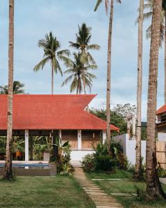 a house with a red roof and palm trees at ANITSA RESORT in El Nido