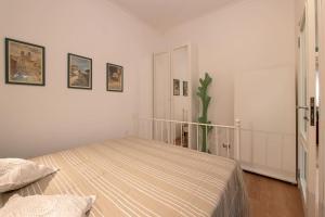 a bedroom with a bed in a white room at Casa Bouganville - St. Peter Romantic Apartment in Rome