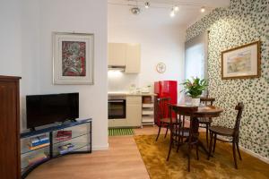 a living room with a dining room table and a kitchen at Casa Bouganville - St. Peter Romantic Apartment in Rome