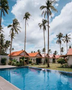 a swimming pool in front of a house with palm trees at ANITSA RESORT in El Nido