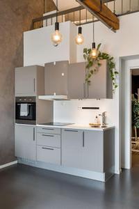 uma cozinha com armários brancos e um fogão em 1-Roms toppleilighet på tangen/bystranda em Kristiansand