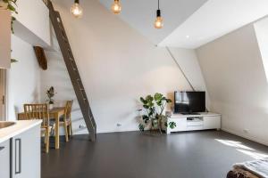 a living room with a tv and a table with chairs at 1-Roms toppleilighet på tangen/bystranda in Kristiansand