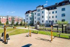 une aire de jeux dans un parc en face d'un bâtiment dans l'établissement 1-Roms toppleilighet på tangen/bystranda, à Kristiansand