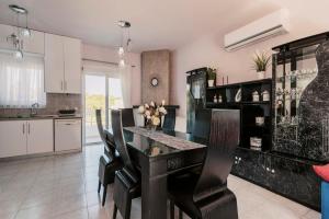 a kitchen with a dining room table and chairs at Greek Style Apartment with Jaquzzi & Barbeque in Triánta