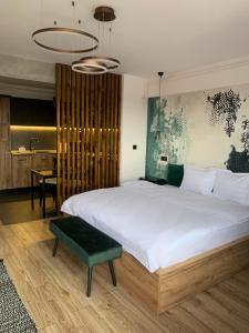 a bedroom with a large white bed and a table at A Guesthouse Sibiu in Sibiu