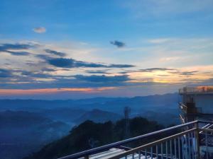 a view of a sunset from a balcony of a mountain at Conifers Homestay in Shimla