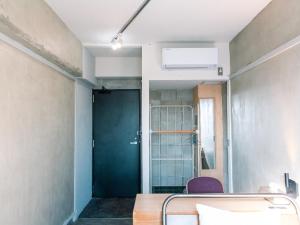 een kamer met een deur en een tafel en stoelen bij Kagan Hotel & Hostel in Kyoto