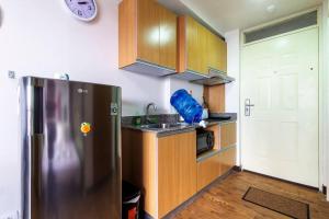 una cucina con frigorifero in acciaio inossidabile e mobili in legno di Antonio's Place, 3 mins to Mactan Airport, Fast Internet with Netflix a Mactan