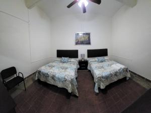 瓦哈卡德華雷斯的住宿－Departamento Arista，客房设有两张床和吊扇。
