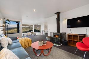 sala de estar con sofá y chimenea en Remarkable Alpine Holiday Home en Queenstown