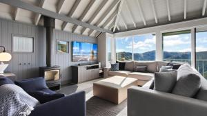a living room with couches and a fireplace and mountains at Bunnys in Mount Hotham