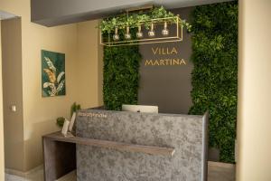 a lobby with a green wall with a sign at Villa Martina in Nesebar