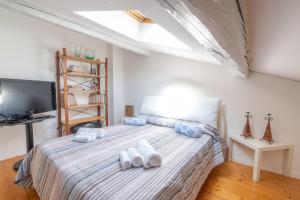 a bedroom with a bed with white towels on it at Piombino Apartments - Casa Fucini in Piombino +4 photos