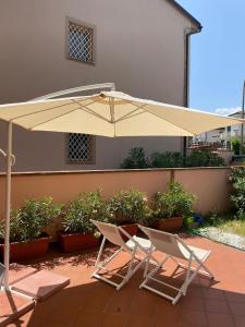 two chairs and an umbrella on a patio at The Loft E&E Open Space in Empoli