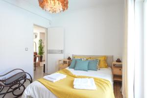 ein Schlafzimmer mit einem großen Bett mit gelben und blauen Kissen in der Unterkunft Hide&Sea Aroeira villa w/ heated pool at the Beach in Aroeira