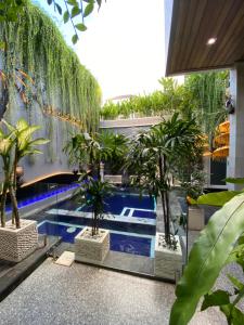 an indoor pool with palm trees in a building at Villa Mabuk in Legian