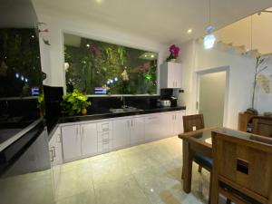 a kitchen with white cabinets and a large aquarium at Villa Mabuk in Legian