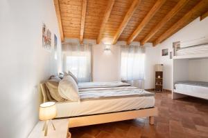 ein Schlafzimmer mit einem großen Bett und einer Holzdecke in der Unterkunft Casale la Coccinella Lavanda in Caprino Veronese