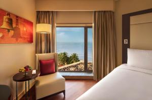 a bedroom with a bed and a view of the ocean at JW Marriott Mumbai Juhu in Mumbai